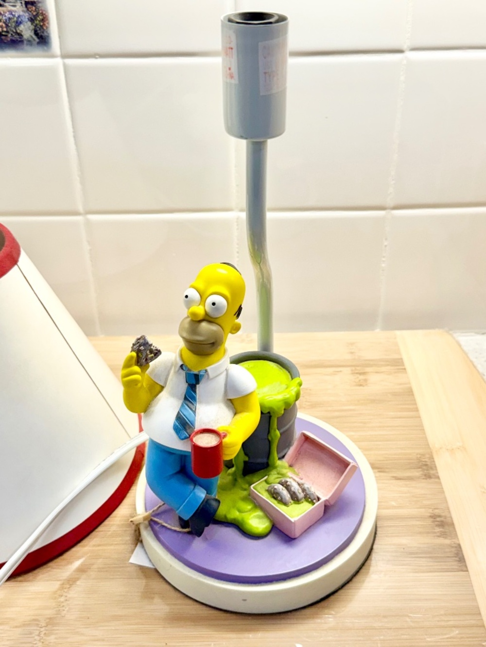 2002 Homer Simpson eating donuts beside a barrel of toxic waste.